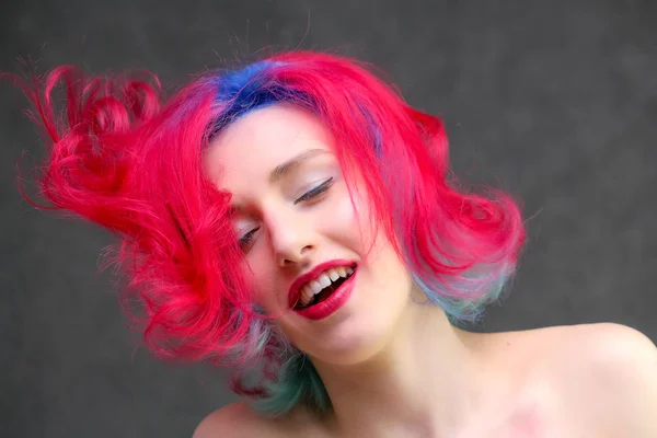 High fashion model woman with multi-colored hair posing in the studio, portrait of a beautiful sexy girl with a fashionable makeup.