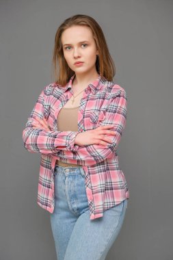 soncept genç neşeli uzun saçlı esmer kadın sıkı kot ve kareli gömlek rahat kıyafetler portresi.