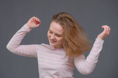 rahat kıyafetler içinde ayakta, saç sallayarak ve konuşmak soncept neşeli uzun saçlı esmer kadın portresi.