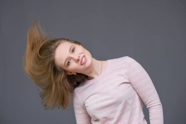 rahat kıyafetler içinde ayakta, saç sallayarak ve konuşmak soncept neşeli uzun saçlı esmer kadın portresi.