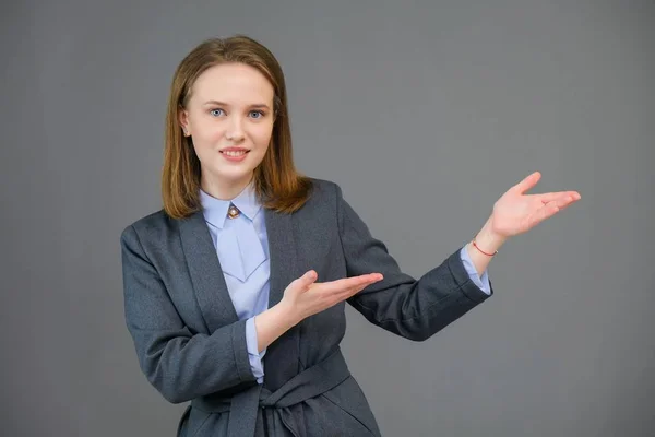 Portret kobiety piękne młody biznes, stojąc na szarym tle. Roześmiany szczęśliwy młoda dziewczyna z naturalny makijaż i piękny uśmiech. — Zdjęcie stockowe