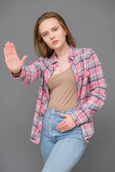 Portrait of soncept young cheerful long-haired brunette woman in casual clothes in tight blue jeans and a checkered shirt. — Stock Photo, Image
