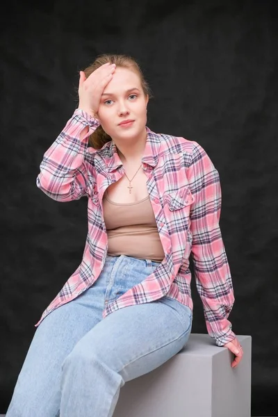 Retrato de soncept joven alegre morena de pelo largo en ropa casual en vaqueros azules ajustados y camisa de patrón a cuadros, hablando . —  Fotos de Stock