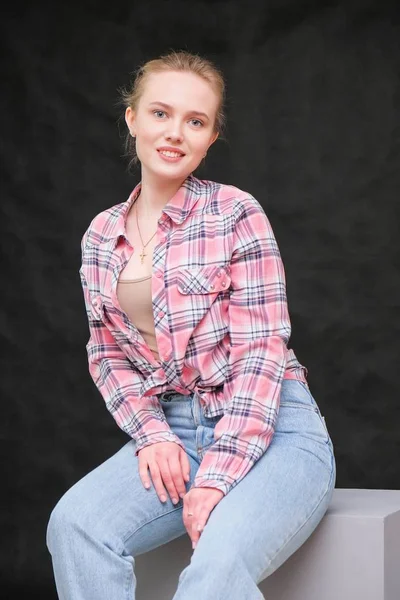 Retrato de soncept joven alegre morena de pelo largo en ropa casual en vaqueros azules ajustados y camisa de patrón a cuadros, hablando . —  Fotos de Stock