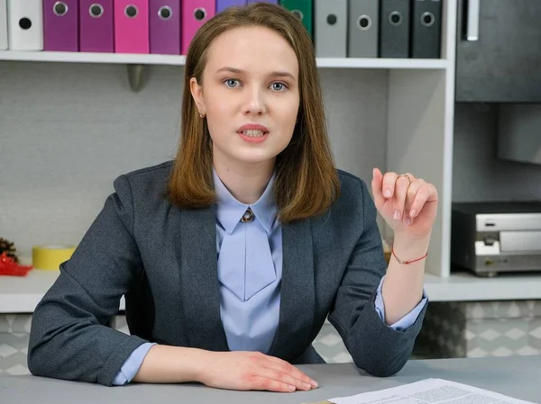 Vista frontal Retrato de gerente elegante sentado en su lugar de trabajo. Concepto de empresa, finanzas y personas: la joven empresaria tiene páginas de papel. Trabajador del periódico . Fotos De Stock