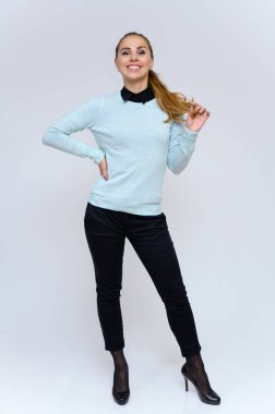 Uzun boylu, sarışın, uzun kıvırcık saçlı, takım elbiseli finans sekreteri bir kızın dikey portresi stüdyoda beyaz arka planda çeşitli pozlarla duruyor..