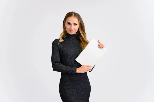 Retrato de una hermosa secretaria rubia con el pelo rizado largo en un vestido gris de pie en el estudio sobre un fondo blanco con una carpeta en las manos con emociones en diferentes poses . — Foto de Stock