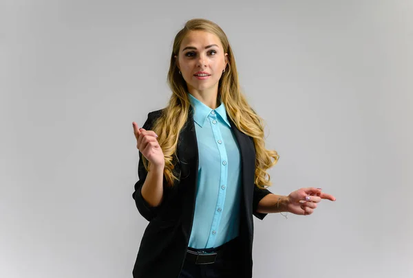 Ritratto di una graziosa segretaria bionda con lunghi capelli ricci in un abito da lavoro in piedi in studio su uno sfondo bianco con emozioni in pose diverse. Arte, affari, bellezza . — Foto Stock