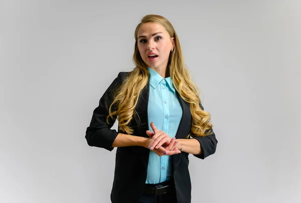 Ritratto di una graziosa segretaria bionda con lunghi capelli ricci in un abito da lavoro in piedi in studio su uno sfondo bianco con emozioni in pose diverse. Arte, affari, bellezza . — Foto Stock