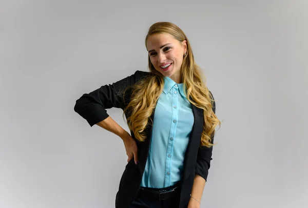 Portrait of a pretty blonde secretary girl with long curly hair in a business suit standing in the studio on a white background with emotions in different poses. Art, business, beauty. — ストック写真