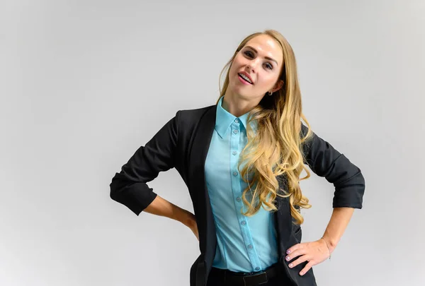 Ritratto di una graziosa segretaria bionda con lunghi capelli ricci in un abito da lavoro in piedi in studio su uno sfondo bianco con emozioni in pose diverse. Arte, affari, bellezza . — Foto Stock