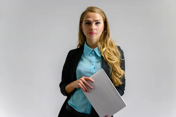 Ritratto di una graziosa segretaria finanziaria bionda con lunghi capelli ricci in un abito da lavoro in piedi in studio su uno sfondo bianco con emozioni in pose diverse con una cartella in mano . — Foto Stock