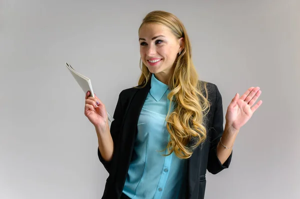 Portrait of a pretty blonde girl financial secretary with long curly hair in a business suit standing in the studio on a white background with emotions in different poses with a folder in his hands. — Stock Photo, Image