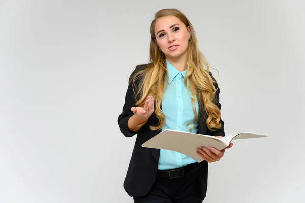 Ritratto di una graziosa segretaria finanziaria bionda con lunghi capelli ricci in un abito da lavoro in piedi in studio su uno sfondo bianco con emozioni in pose diverse con una cartella in mano . — Foto Stock