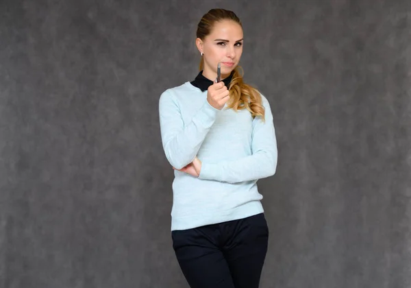 Porträt eines hübschen blonden Finanzsekretärsmädchens mit langen lockigen Haaren im Business-Anzug, das im Studio vor grauem Hintergrund steht und Emotionen in verschiedenen Posen zeigt. — Stockfoto