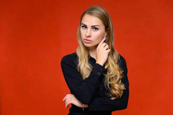 Porträt eines hübschen blonden Finanzsekretärsmädchens mit langen lockigen Haaren im Business-Anzug, das im Studio vor rotem Hintergrund steht und Emotionen in verschiedenen Posen zeigt. — Stockfoto