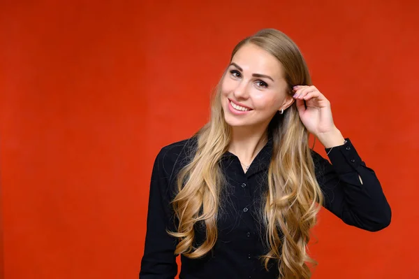 Retrato de una hermosa secretaria financiera rubia con el pelo rizado largo en un traje de negocios de pie en el estudio sobre un fondo rojo con emociones en diferentes poses . — Foto de Stock