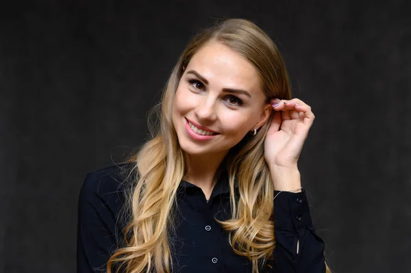 Portretul apropiat al unei fete blonde, cu părul lung creț, care stă în studio pe un fundal gri, cu emoții în diferite poziții. Frumusețe, Model, Cosmetice — Fotografie, imagine de stoc