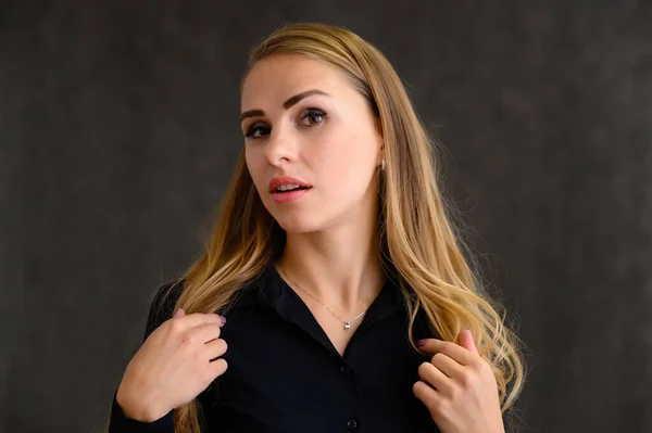 Ritratto ravvicinato di una bella ragazza bionda con lunghi capelli ricci in piedi in studio su uno sfondo grigio con emozioni in pose diverse. Bellezza, Modella, Cosmetici — Foto Stock