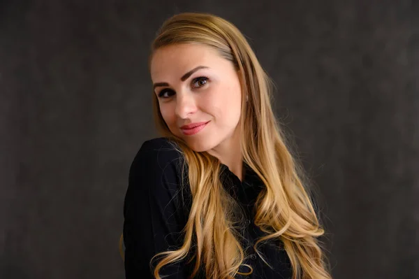 Close-up portrait of a pretty blonde girl with long curly hair standing in the studio on a gray background with emotions in different poses. Beauty, Model, Cosmetics — Stock Photo, Image