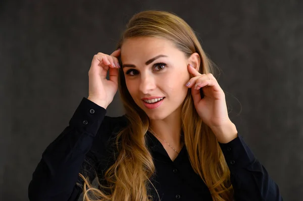 Retrato de cerca de una hermosa chica rubia con el pelo largo y rizado de pie en el estudio sobre un fondo gris con emociones en diferentes poses. Belleza, Modelo, Cosméticos — Foto de Stock