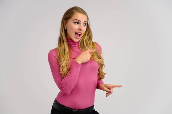 Close-up portrait of a pretty blonde girl with long curly hair standing in the studio on a white background with emotions in different poses in a pink sweater. Beauty, Model, Cosmetics — Stock Photo, Image