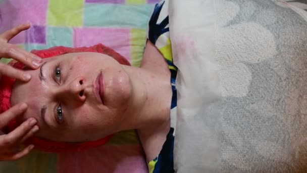 Een cosmetoloog voert gezichtsmassage, het maken van een myoplastische massage aan een vrouw — Stockvideo