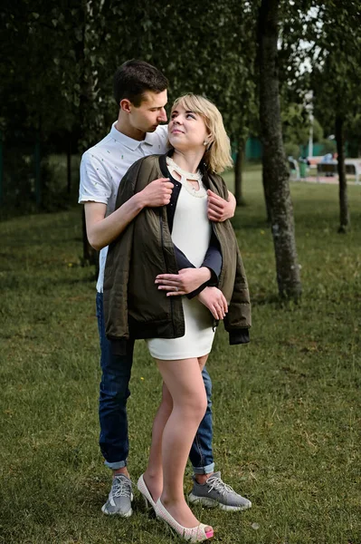 Conceito de fotografia de família. Retrato vertical de um jovem caucasiano. Um jovem casal está de pé em um parque — Fotografia de Stock