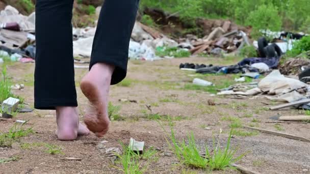 Legs of a man walking on a path near trash and garbage in the open air. — Stock Video