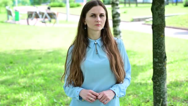 Video Caucásico morena chica con el pelo largo pensamiento en el parque . — Vídeo de stock