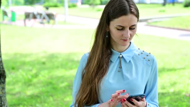 Eine Frau wählt am Telefon die Nummer, dann spricht sie und lächelt. — Stockvideo