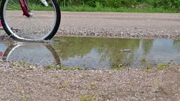 Långsam rörelse video av cykel hjul rida genom en pöl. — Stockvideo