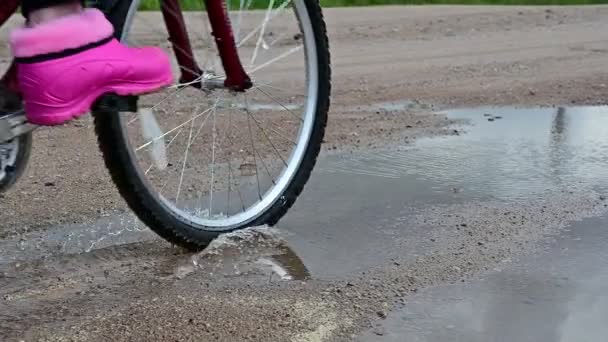 Powolny film z jazdy na rowerze przez kałużę. — Wideo stockowe