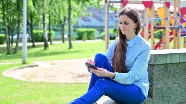 Güneşli bir havada akıllı telefonla poz vermek..