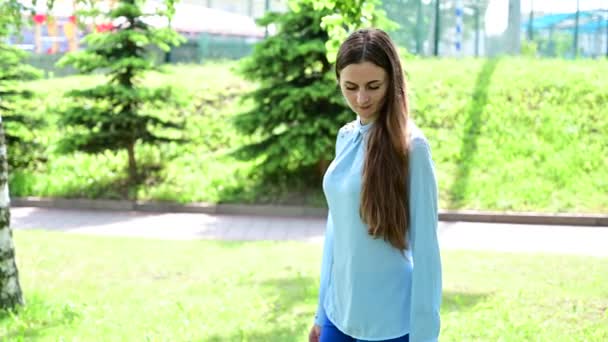 Video Kaukasiska brunett i parken missnöjda promenader. — Stockvideo