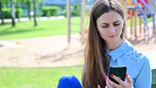 Vídeo Caucásico morena en el parque hablando por teléfono . — Vídeos de Stock