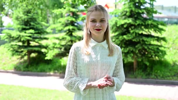 Retrato de una modelo caucásica sonriente con excelente maquillaje en el parque en tiempo soleado. Video de una guapa rubia — Vídeos de Stock