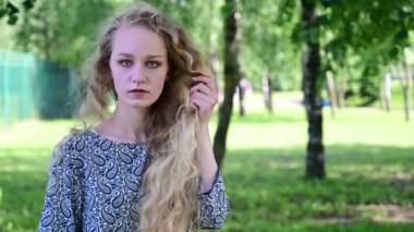 Kafkasyalı bir sarışının parkta durduğunu gösteren bir video..