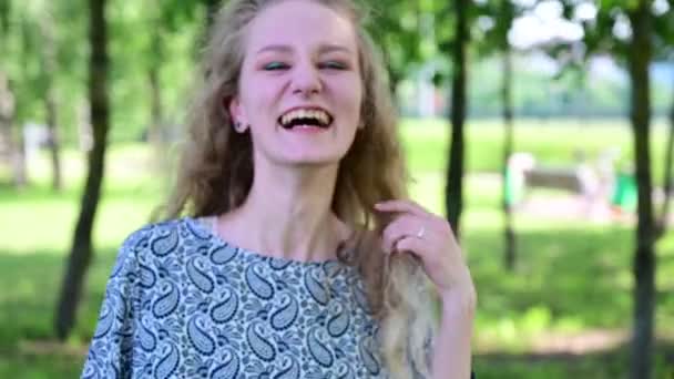 Film białej blondynki śmiejącej się zaraźliwie w parku. — Wideo stockowe