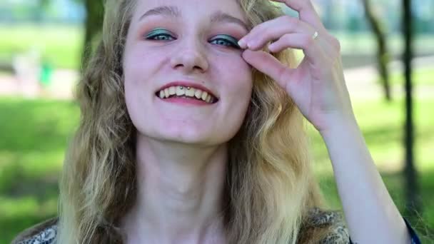 Video de una rubia caucásica con el pelo hermoso riendo en un parque . — Vídeo de stock