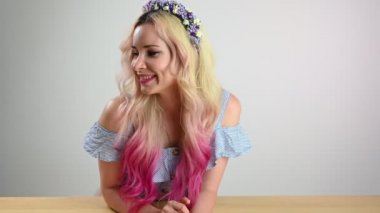 Kafasında çelenk olan, beyaz arka planda gülümseyen aktif, neşeli bir kadın..