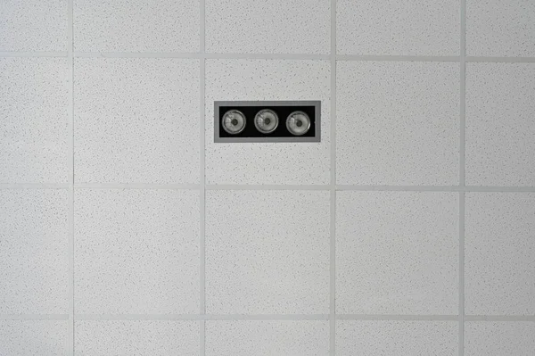Photo of the ceiling in a building with lighting and alarm elements.