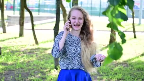 La fille blonde rit joyeusement et contagieusement tout en parlant sur le smartphone. — Video