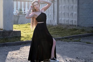 Şehirde uzun saçlı, modaya uygun, beyaz bir genç kadının yakın plan portresi. Açık havada poz veren güzel bir model.