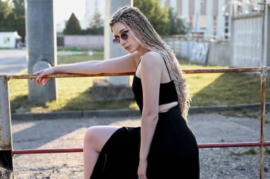 Açık havada poz veren güzel bir model. Şehirde uzun saçlı, modaya uygun, beyaz bir kadının yakın plan portresi.