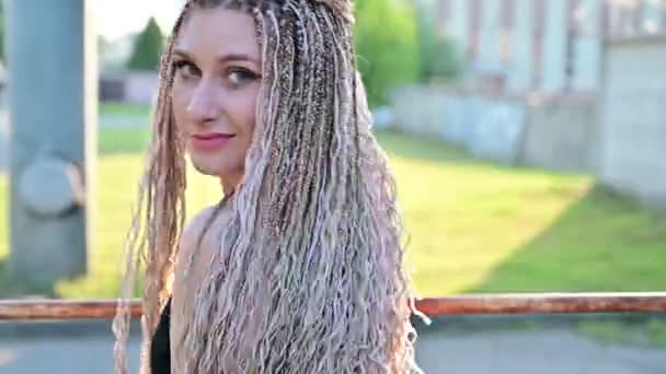 Blanke mooie vrouw met dreadlocks poseren buiten. — Stockvideo