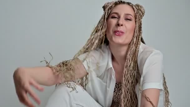 Caucasian pretty woman with dreadlocks posing in studio. — Stock Video