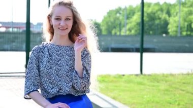 Güzel, modaya uygun model hafifçe gülümsüyor, sokakta poz veriyor.