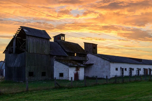 Photo of destroyed old buildings in autumn against the background of a dramatic sky in the orange setting sun — Stock Photo, Image