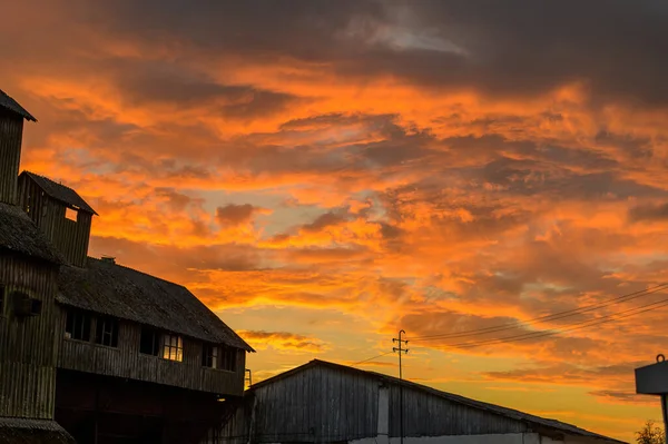 Paisagem foto no pôr-do-sol laranja de edifícios antigos abandonados no outono contra o pano de fundo de um céu dramático — Fotografia de Stock